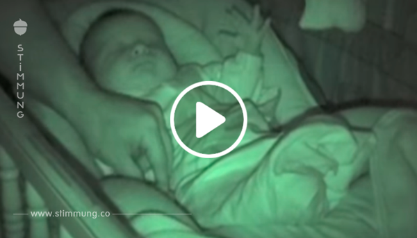 Vater bedeckt die kalten Hände des Babies mit der Decke – doch dann fängt die Kamera etwas Eigenartiges ein