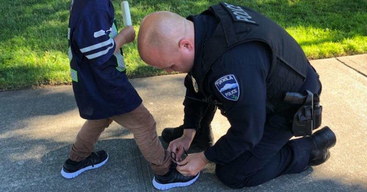 Polizist hilft kleinem Jungen mit blutigen Socken.	
