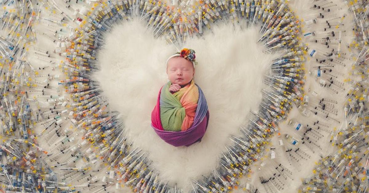 Baby mit Spritzen fotografiert, die zur Geburt nötig waren.