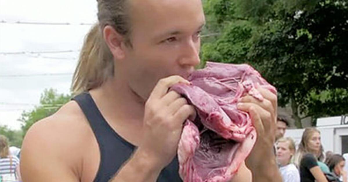 Mann isst rohes Fleisch auf veganer Veranstaltung – steht in Pfütze aus Fett und Blut	