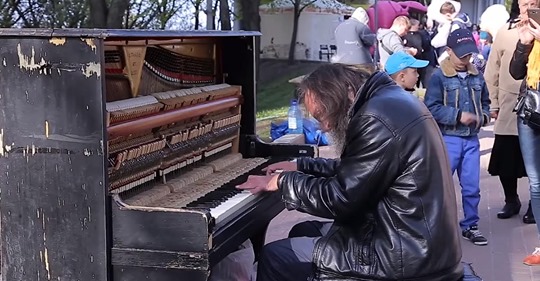 Obdachloser Mann setzt sich an kaputtes Klavier auf der Straße und jeder will ihm zuhören