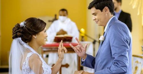 Ein Priester führt die Hochzeitszeremonie eines taubstummen Brautpaars in Zeichensprache durch: eine inklusive Hochzeit